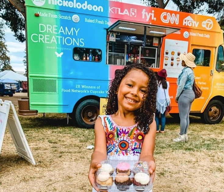 Girl in front of cupcaketruck holding cupcakes